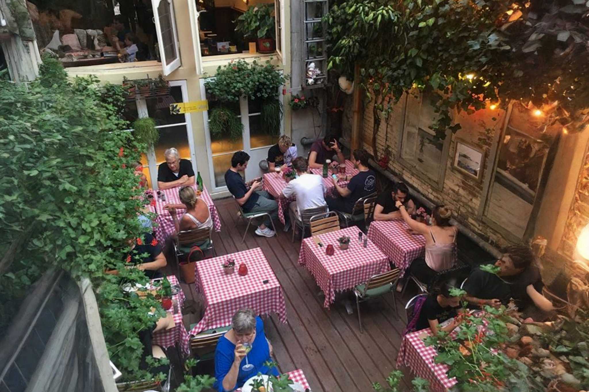 🍝 Lucca Due餐厅温馨内景：粉红桌布与暖光营造的意式浪漫 - 砖墙、木质桌椅与开放式厨房在粉色调中更显温馨