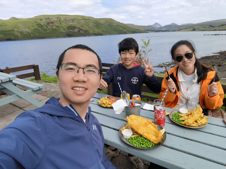 全家在临海木质野餐桌旁休息合影