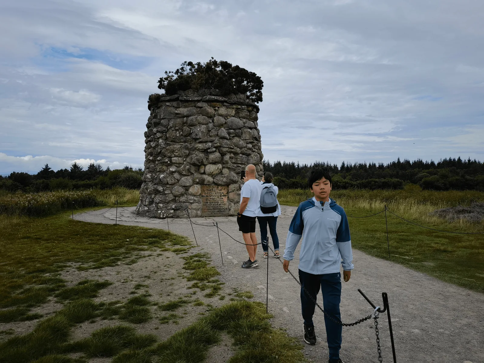 Feynman 走近 Culloden 石砌纪念塔,周围游客停留。
