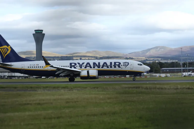 Ryanair Boeing 737 EI-ILN 侧影,背景是爱丁堡塔台与丘陵。
