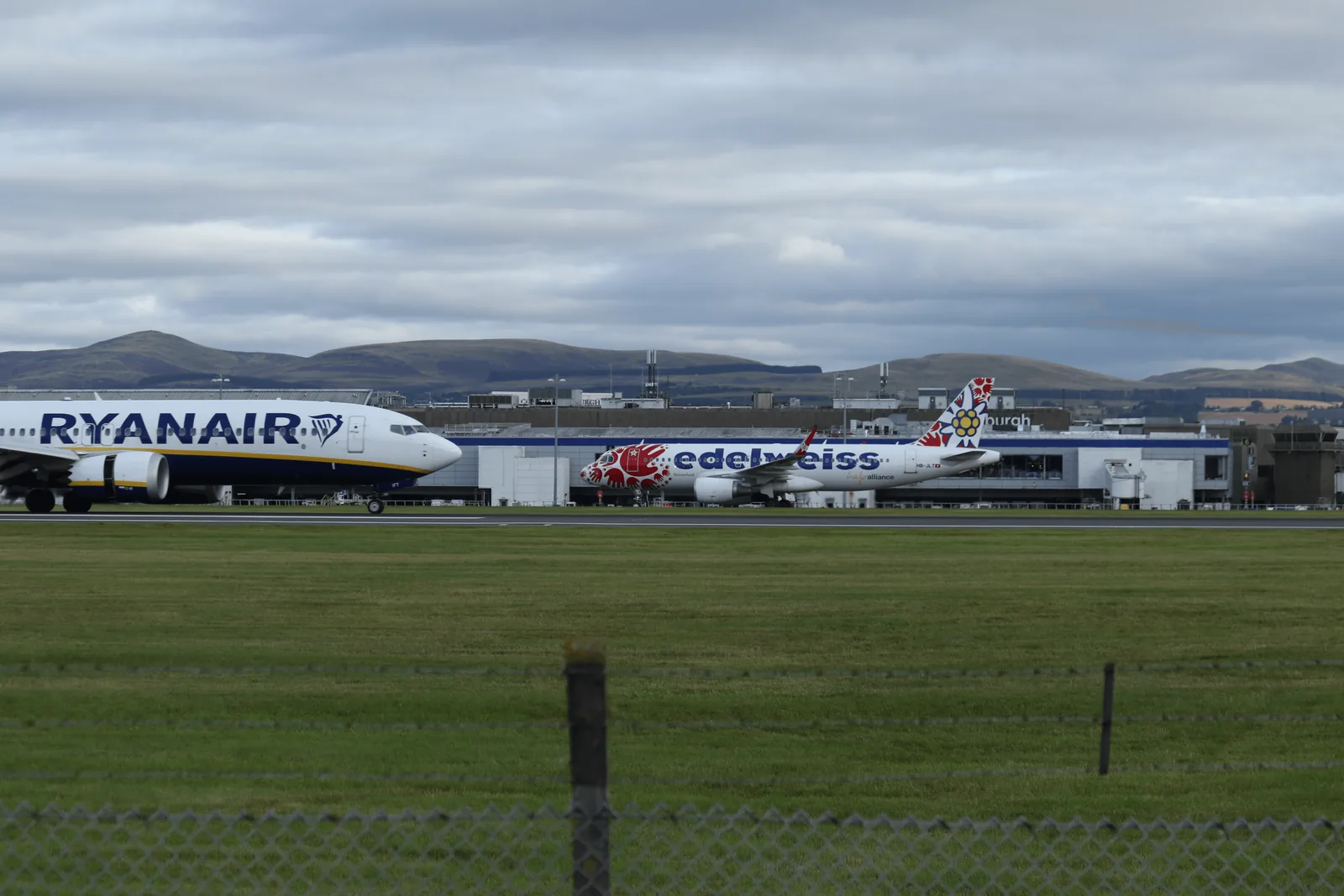 近处 Ryanair 机头与后方 Edelweiss,航站楼可见 Edinburgh 字样。