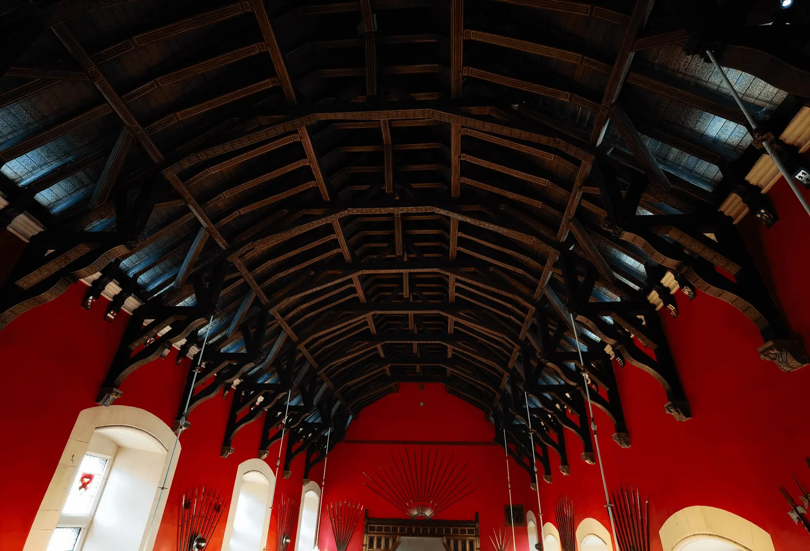 Great Hall 内从入口仰望的木构屋顶与红色墙面。