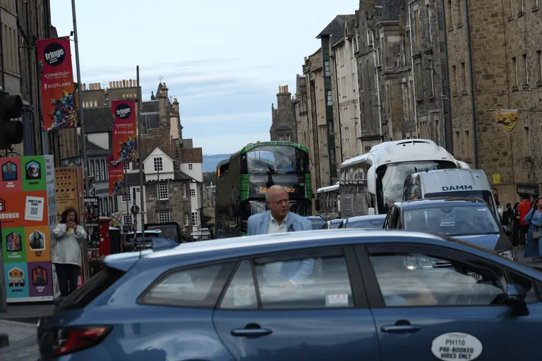 Royal Mile 上的车辆、行人与节庆旗帜。