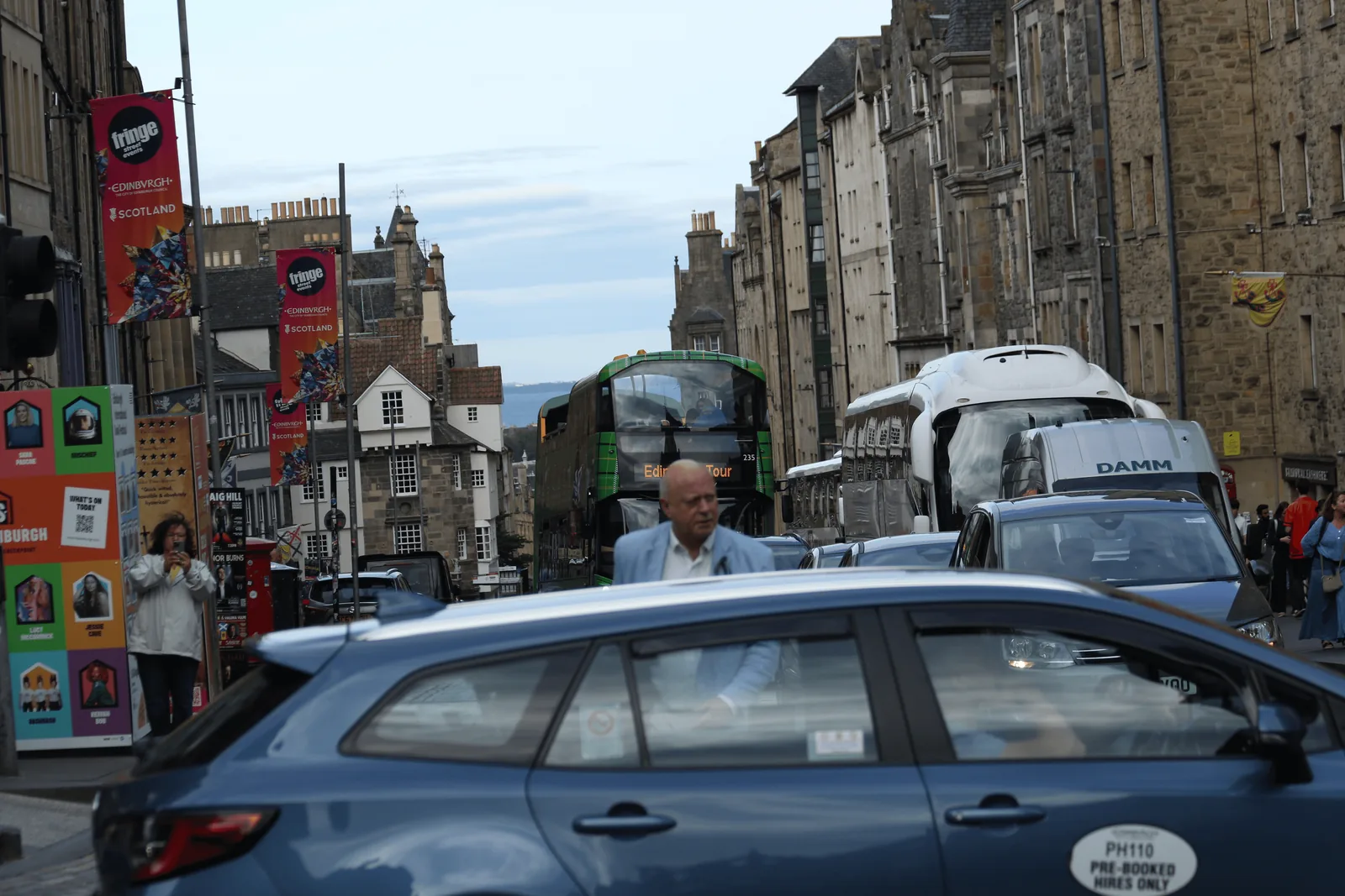 Royal Mile 上的车辆、行人与节庆旗帜。