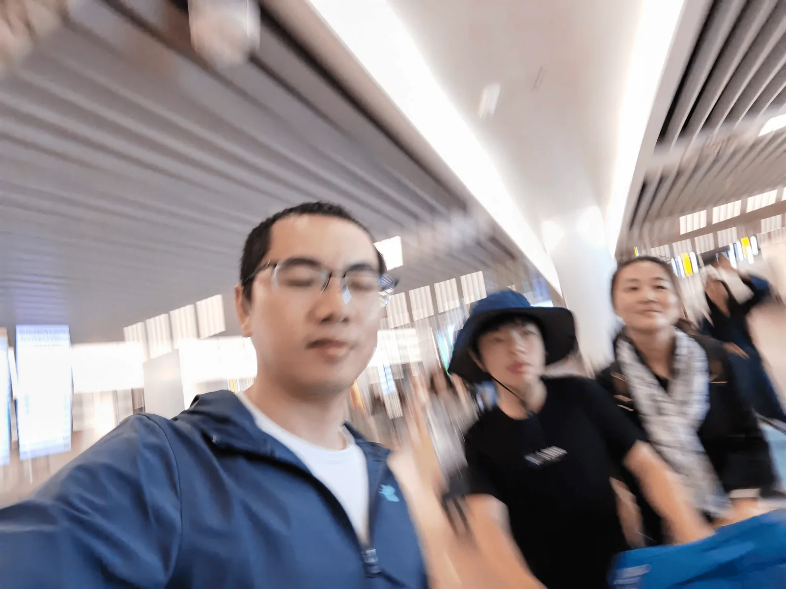 家人推着行李箱穿过机场大厅通道