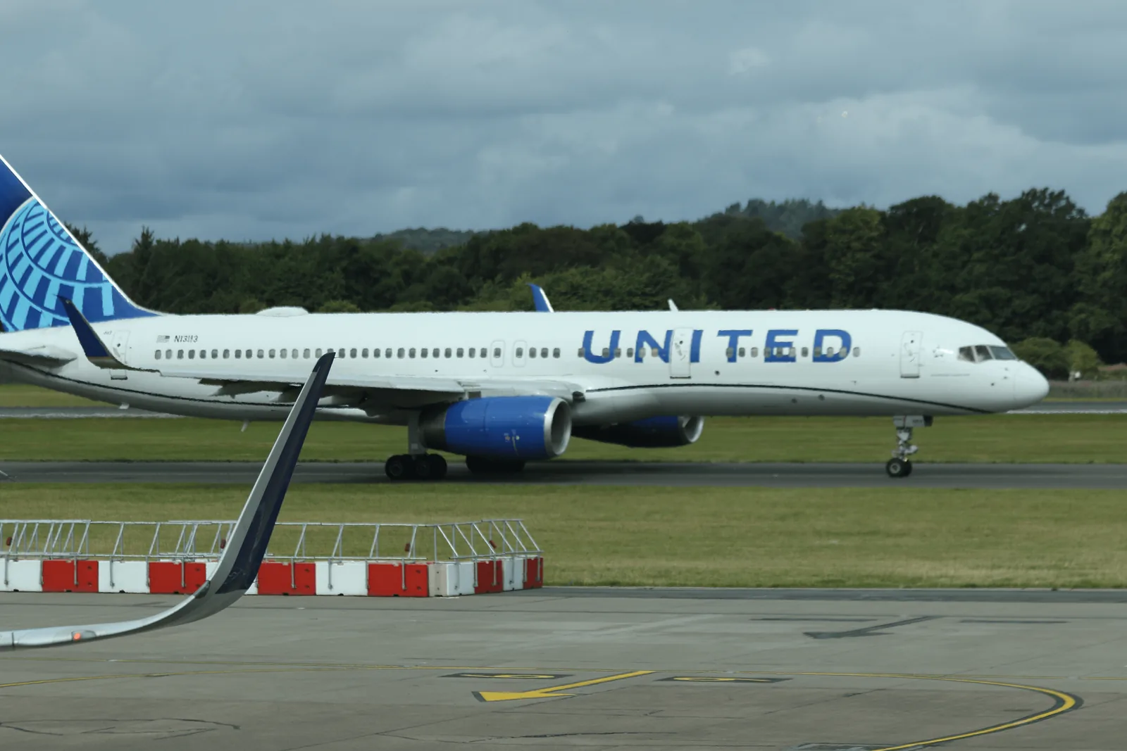 United Airlines 涂装客机在跑道区域滑行，机身可见 UNITED 字样