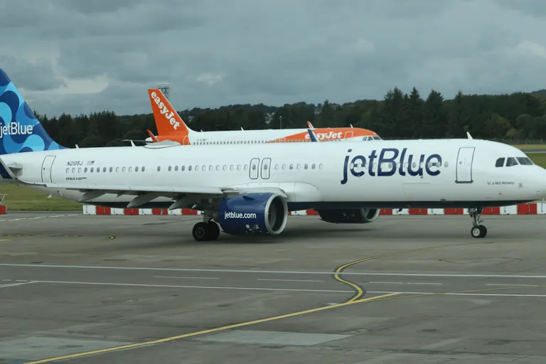 JetBlue 涂装客机在跑道区域滑行。