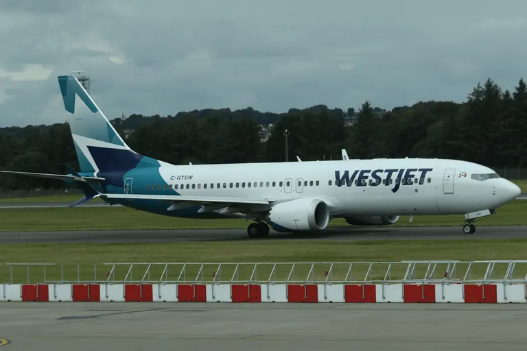 WestJet 涂装客机在跑道区域滑行。