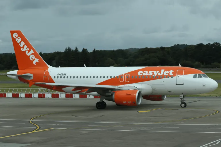 easyJet 涂装客机在跑道区域滑行。